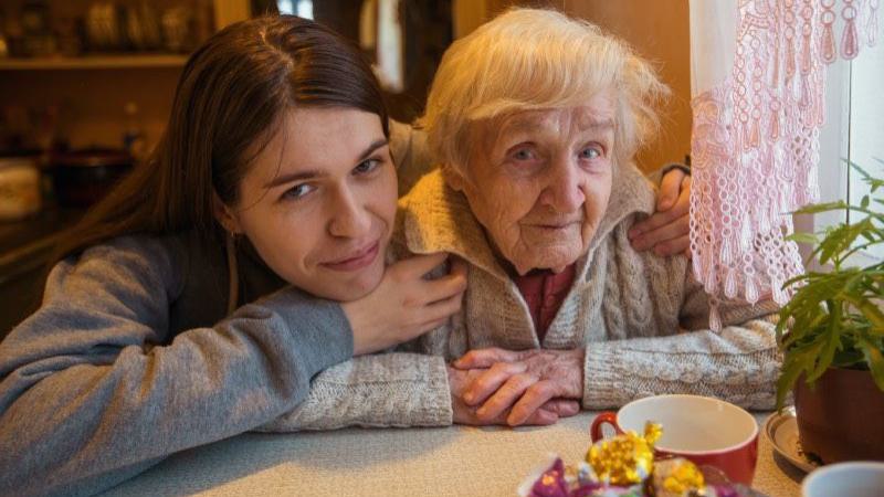 Enkelin mit ihrer Oma bei einer Tasse Tee in liebvoller Atmosphäre